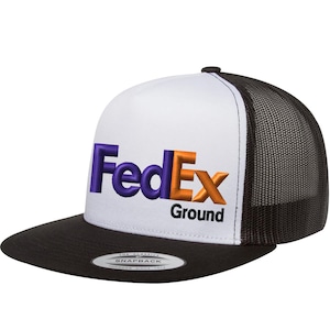 Puede incluir: Gorra de camionero blanca y negra con un logotipo de FedEx Ground bordado en morado y naranja.