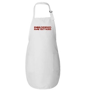 Puede incluir: Delantal blanco con un bolsillo grande en la parte delantera. El delantal tiene correas ajustables y el texto "EMBROIDERED NAME TEXT WORD" está bordado en rojo en la parte delantera.