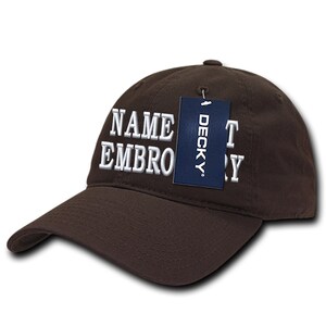 Puede incluir: Gorra de béisbol marrón con texto bordado en blanco que dice "NAME EMBROIDERY" y una etiqueta azul que dice "DECKY".