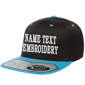 Puede incluir: Gorra de béisbol negra y azul con texto bordado en blanco que dice "NAME TEXT EMBROIDERY". La gorra tiene una visera azul y una corona negra. La gorra tiene un logotipo Flexfit en la visera.