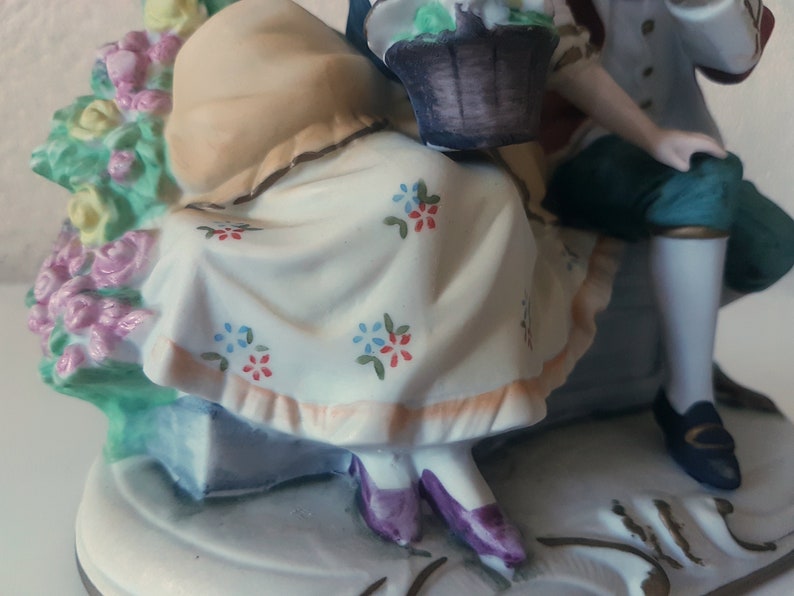 Large vintage porcelain figurine young Couple with flowers sitting on a rock