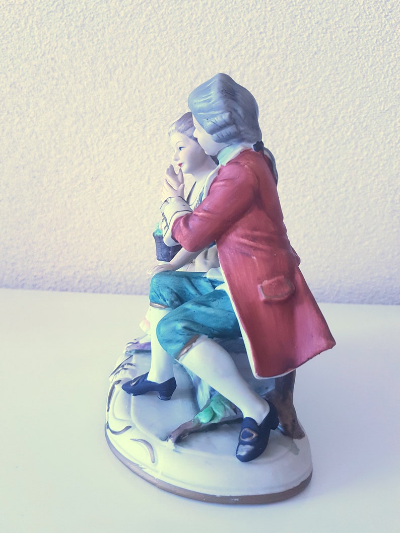 Large vintage porcelain figurine young Couple with flowers sitting on a rock