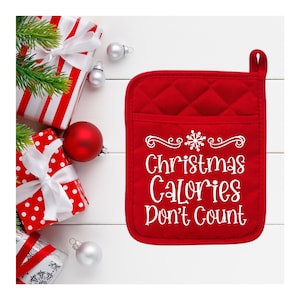 May include: Red quilted oven mitt with a white snowflake and the text "Christmas Calories Don't Count".