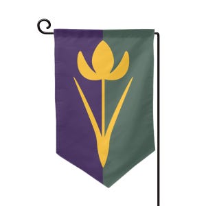 Puede incluir: Una bandera de jardín con un diseño dividido. Un lado es de color púrpura oscuro, el otro es verde oliva. Un diseño de tulipán amarillo está centrado en la bandera. La bandera cuelga de un poste de jardín de metal negro.