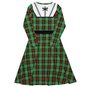 May include: A long-sleeved dress featuring a green, red, and black plaid pattern. The dress has a white collar with a black bow and trim, and a black belt at the waist. The dress is a-line and made of a soft material.