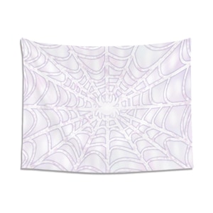May include: White tapestry featuring a spider web design with a spider in the center. The web has a detailed, symmetrical pattern with a light purple hue. The tapestry is rectangular and hangs against a white background.