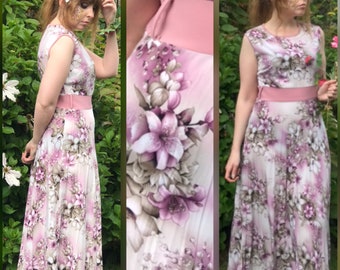 May include: A sleeveless maxi dress with a pink floral print and a pink waistband. The dress has a flowing skirt and a fitted bodice.