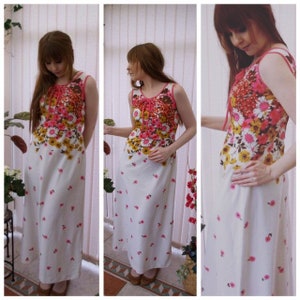May include: A white maxi dress with a floral print in shades of pink, yellow, and brown. The dress has a sleeveless design and a V-neckline.