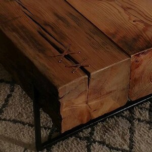 Pu&ograve; includere: Un tavolino da caff&egrave; in legno rustico con una struttura in metallo. Il piano del tavolo &egrave; realizzato con spessi assi di legno riciclato che sono stati uniti con cinghie in pelle. Il tavolo ha una finitura naturale e invecchiata.