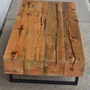 Pu&ograve; includere: Un tavolino da caff&egrave; in legno rustico con una struttura in metallo nero. Il piano del tavolo &egrave; realizzato con assi di legno riciclato con una finitura naturale.