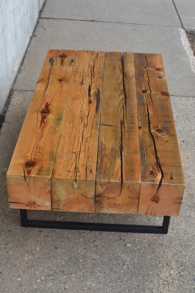 Pu&ograve; includere: Un tavolino da caff&egrave; in legno rustico con una struttura in metallo nero. Il piano del tavolo &egrave; realizzato con assi di legno riciclato con una finitura naturale.