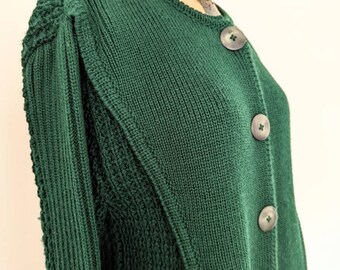 Pode incluir: Um cardigan de malha verde escuro com fecho de botões. O cardigan tem um padrão de malha texturizado e uma silhueta ligeiramente ajustada.