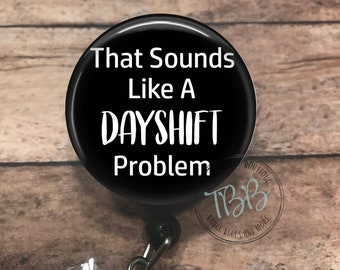 May include: Black and white badge reel with a black button that says "That Sounds Like A Dayshift Problem".