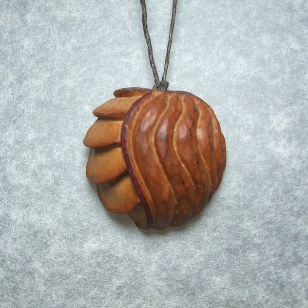 Pendentif Faux-fossile ou Coquillage sculpté dans du noyau d'avocat, upcycling