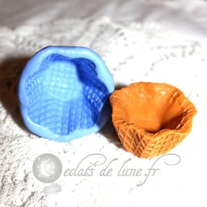 Könnte beinhalten: Zwei Silikonformen zum Backen, eine blaue und eine orange. Die blaue Form ist wie ein Waffelkegel geformt und die orange Form wie ein kleiner Korb.