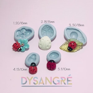 Könnte beinhalten: Fünf Silikonformen zum Herstellen von handgefertigten Gegenständen zum Thema Marienkäfer. Die Formen sind in verschiedenen Größen von 10 mm bis 18 mm erhältlich. Die Formen sind blau und haben verschiedene Designs, darunter einen Marienkäfer auf einem Blatt, einen Marienkäfer auf einer Blume und einen Marienkäfer allein.