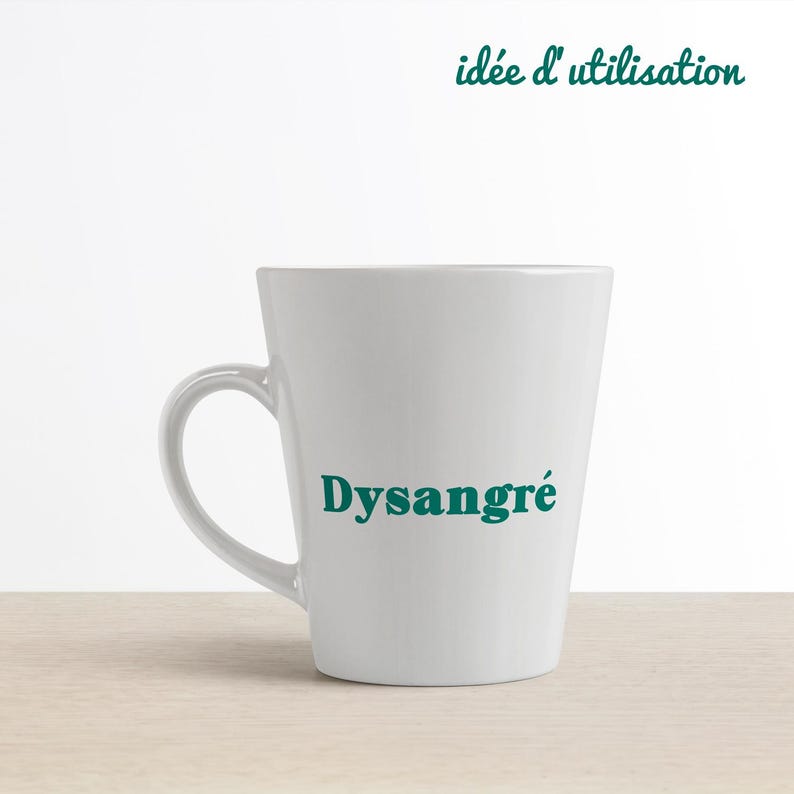 May include: White ceramic mug with a teal green inscription that reads "Dysangr&eacute;".