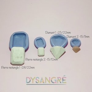 Puede incluir: Un conjunto de cuatro moldes de silicona para hacer joyas. Los moldes son azules y presentan diferentes formas, incluyendo un diamante, un rectángulo y una lágrima. El texto "Diamant 1-25/22mm", "Diamant 2-15/11mm", "Pierre rectangle 2-15/10mm" y "Pierre rectangle 1-28/22mm" está impreso en el fondo.