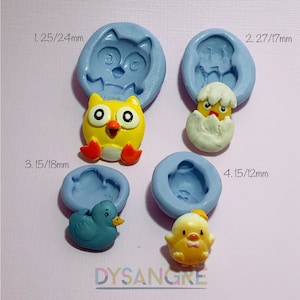 Op de afbeelding: Een verzameling van vier siliconen mallen en bijbehorende beeldjes. De lichtblauwe mallen tonen een uil, een kuiken dat uit een ei komt, een blauwe eend en een geel kuiken. De tekst "DYSANGRE" is zichtbaar.