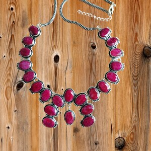 Può includere: Una collana d'argento con un design a cascata di grandi pietre ovali di colore rosa scuro.