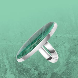 May include: A silver ring with a large oval green malachite stone.