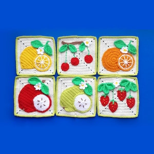 May include: Six crocheted squares featuring fruit designs. The fruits depicted are a lemon, cherries, an orange, an apple, a pear, and strawberries. Each square has a white background with a green border, set against a blue backdrop.