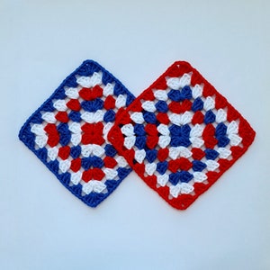 May include: Two crocheted squares in red, white, and blue. The squares are made with a granny stitch pattern.