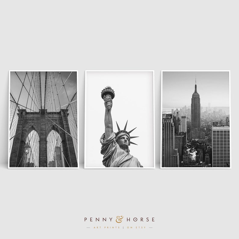 May include: A set of three black and white photographs featuring iconic New York City landmarks: the Brooklyn Bridge, the Statue of Liberty, and the Empire State Building.