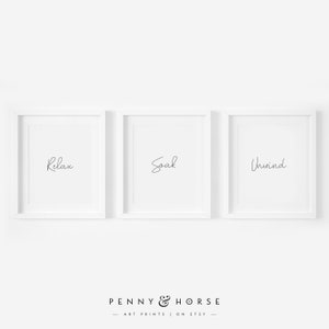 May include: Three white framed prints with the words "Relax", "Soak", and "Unwind" in black script.