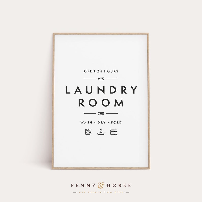 May include: A framed laundry room sign with the text "OPEN 24 HOURS" and "LAUNDRY ROOM" in a minimalist black and white design. Below the text are icons for washing, drying, and folding. The sign is from Penny & Horse.
