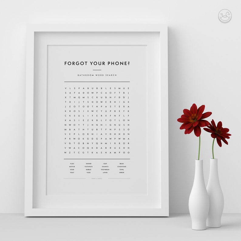 Op de afbeelding: Een ingelijst afdruk met een zwart-witte woordzoeker. De titel van de puzzel is "Forgot Your Phone?" en de ondertitel is "Bathroom Word Search". De puzzel is gevuld met letters en de woorden die je moet vinden staan onder de puzzel. De afdruk is op een witte achtergrond en is ingelijst in een wit frame.