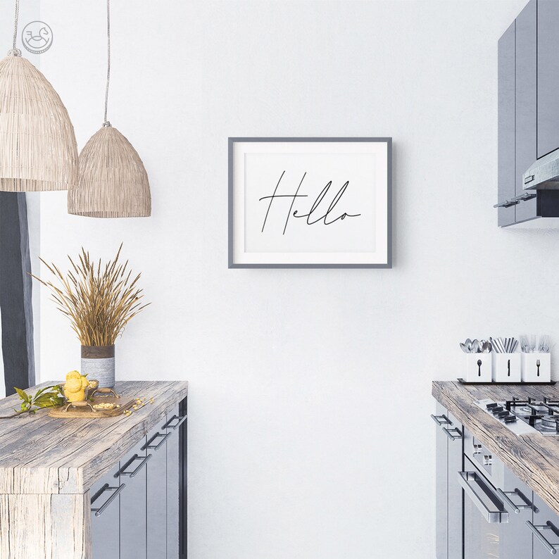 K&ouml;nnte beinhalten: Ein gerahmter Druck mit dem Wort "Hello" in moderner Kalligrafie. Der Druck h&auml;ngt an einer wei&szlig;en Wand in einer K&uuml;che.
