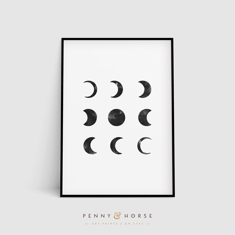 May include: A black and white printable art print featuring a minimalist design of nine moons in different phases. The print is framed in a black frame and has the text "PENNY & HORSE ART PRINTS | ON ETSY" at the bottom.