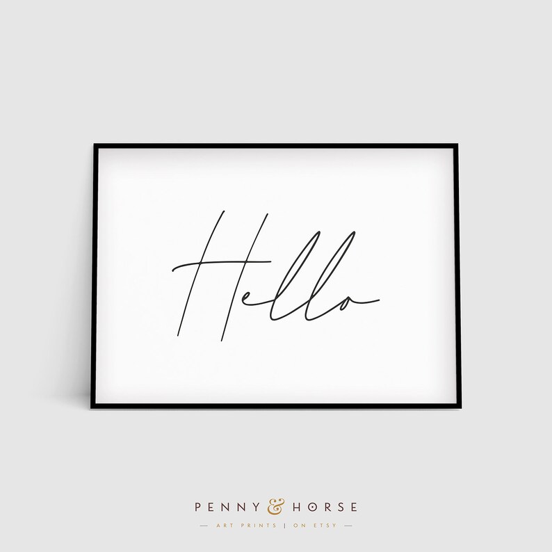 K&ouml;nnte beinhalten: Ein schwarzer gerahmter Druck mit dem Wort "hello" in einer einfachen, handschriftlichen Schrift auf wei&szlig;em Hintergrund.