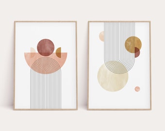 May include: Two abstract art prints with geometric shapes in shades of pink, brown, and gold. The prints feature curved lines and circles, creating a modern and minimalist aesthetic.
