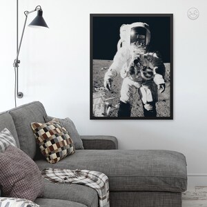 May include: A black and white photograph of an astronaut in a spacesuit standing on the moon. The astronaut is wearing a helmet and is holding a camera. The background is a dark, starry sky.