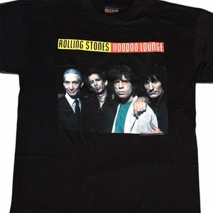 Könnte beinhalten: Schwarzes T-Shirt mit einem gelben und roten Band über der Brust, auf dem "Rolling Stones Voodoo Lounge" steht. Das Band befindet sich über einem Foto der Mitglieder der Rolling Stones.