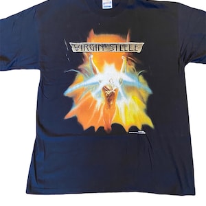 May include: Black t-shirt with a graphic of a person with arms raised in the air, surrounded by a bright orange and yellow light. The text "VIRGIN STEELE" is printed in silver above the graphic.