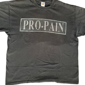 May include: Black t-shirt with a white "PRO-PAIN" graphic printed on the front.
