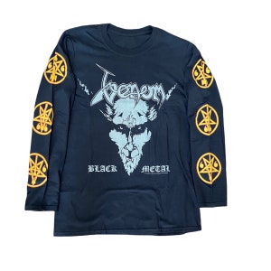 May include: Black long-sleeve t-shirt with a graphic of a demon's face and the text "Venom Black Metal". The sleeves have a repeating pattern of pentagrams.
