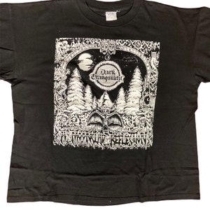 May include: Black t-shirt featuring a white graphic print of a forest scene with a crescent moon and the text "Dark Tranquillity".