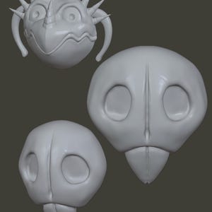 May include: Three grey, stylised, cartoonish creature heads. One has a spiky crown, a horn, and handles. The other two have large eye sockets and a beak-like lower jaw. The heads are on a grey background.