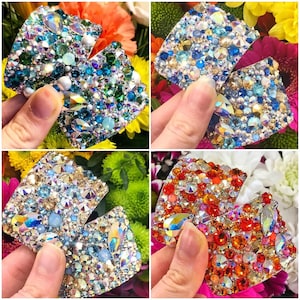 May include: Four pairs of rhinestone embellishments in different colors. Each pair is made of small, faceted rhinestones in a variety of colors, including blue, green, red, and orange. The rhinestones are arranged in a random pattern, creating a sparkling and eye-catching effect.