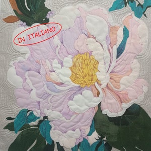 Può includere: Primo piano di un fiore rosa e bianco con un centro giallo. Il fiore è circondato da foglie verdi. Il testo "IN ITALIANO" è scritto in rosso su un cerchio bianco.