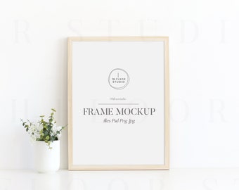 May include: A light wood frame mockup with a white background. The frame is sitting on a white surface. The text "FRAME MOCKUP" is printed on the frame. The text "files: Psd Png Jpg" is printed below the text "FRAME MOCKUP".
