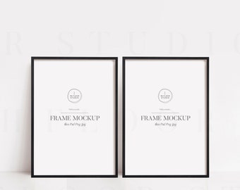 May include: Two black picture frames with white mats and a white background. The frames are empty and have the text "FRAME MOCKUP" and "The Floor Studio" printed on them.