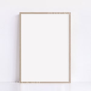May include: A light brown wood picture frame with a white mat and a white background.