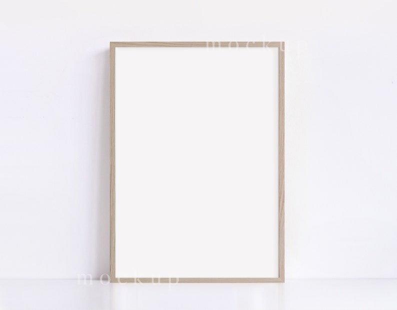 May include: A light brown wood picture frame with a white mat and a white background.