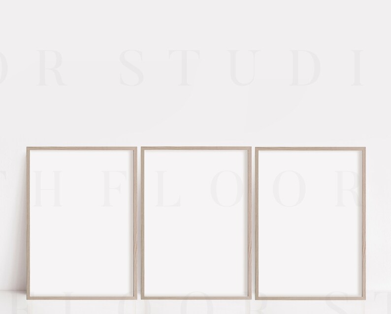 May include: Three light wood picture frames with white mats and white backgrounds. The frames are arranged horizontally in a row.