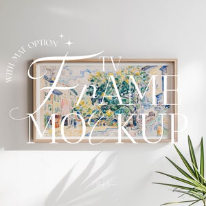 May include: A framed watercolor painting of a street scene with buildings and trees. The frame is light wood with a white mat. The text "TV FRAME MOCKUP" is written in white cursive letters over the image.